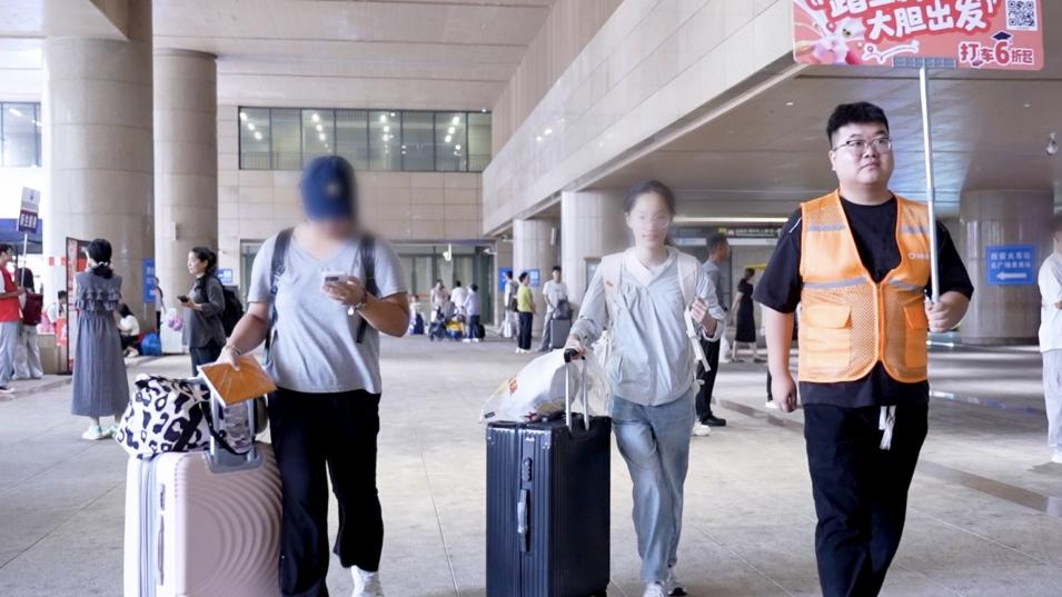图为:西安站滴滴引导员引导学生前往大巴上车点 配图2
